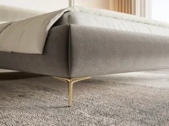 Łóżko tapicerowane 140x200 cm Roule z pojemnikiem stelaż metalowy szarobeżowe welur hydrofobowy nóżki złote
