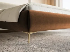 Łóżko tapicerowane 140x200 cm Roule z pojemnikiem stelaż metalowy miedziane welur hydrofobowy nóżki złote